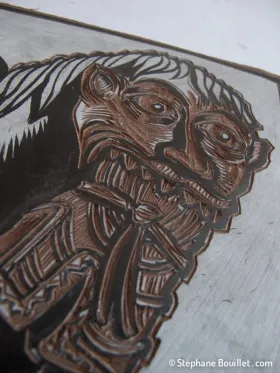Fin de la gravure: avoir un dessin fortement contrasté en noir sur blanc permet d'être plus précis que noir sur le brun foncé du linoleum On ne suit pas forcément au millimètre le dessin de base, au contraire même: ne pas hésiter à rajouter ou modifier des traits pour utiliser toute la panoplie d'effets offerts par la linogravure (comme autour du nez et la machoire du personnage du dessus: j'ai laissé davantage de blanc = de partie qui seront noires)