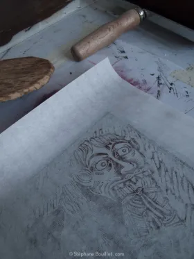 Début d'impression de l'estampe sur le linoléum au baren