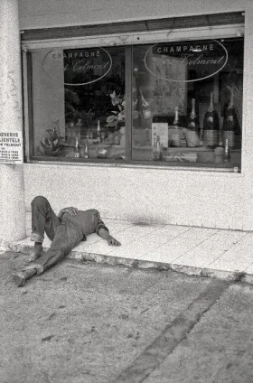 Homme allongé devant un magasin de Champagne